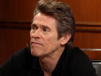 Willem Dafoe is wearing a black shirt.